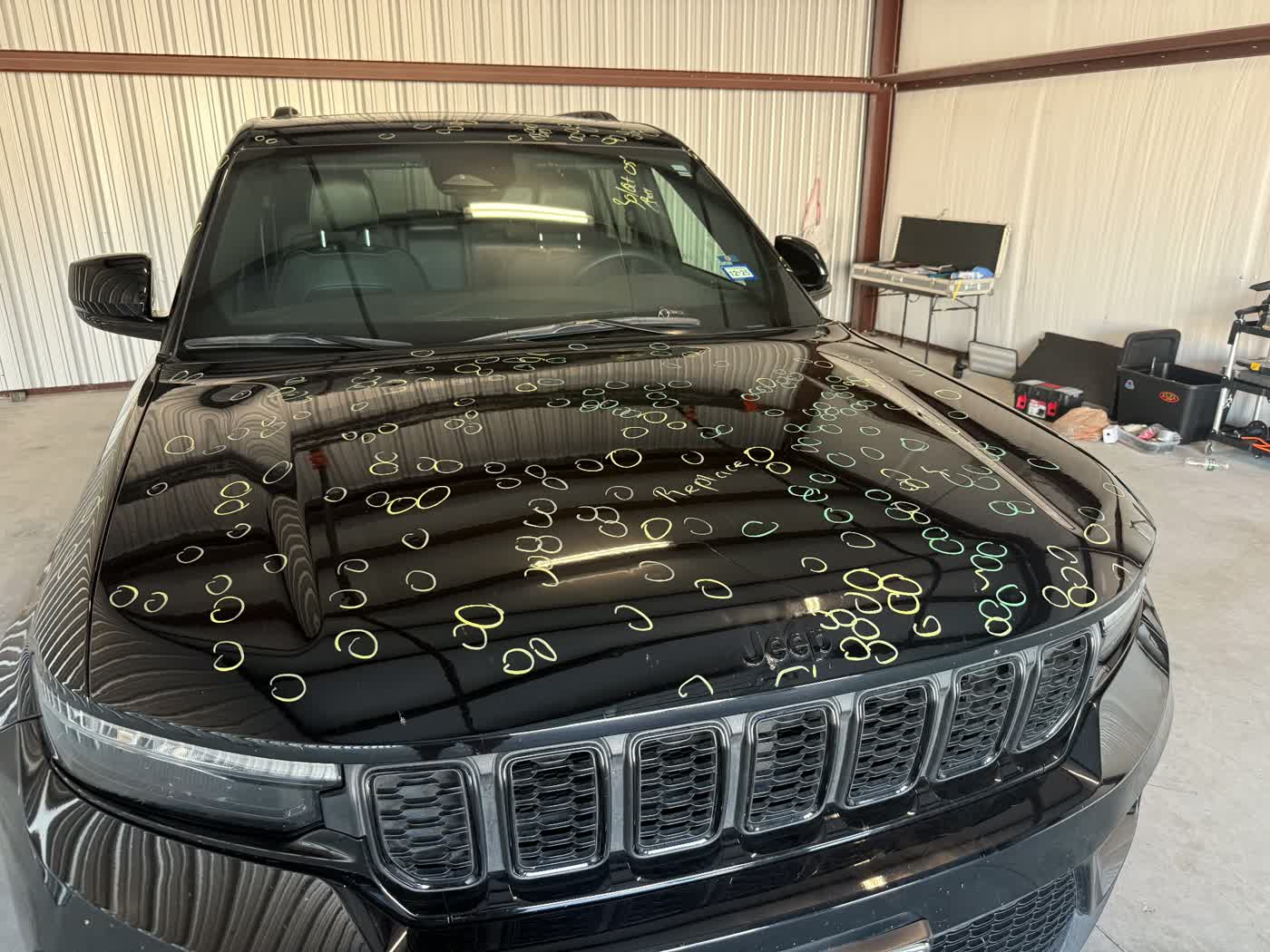 Hail dents marked on a black SUV hood